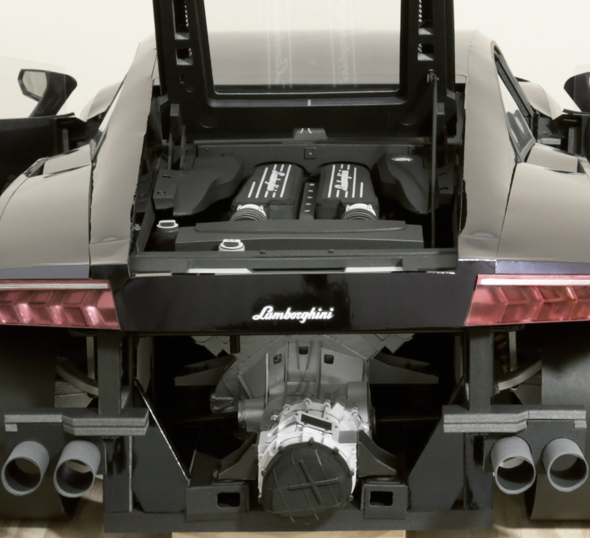 Close up showing the engine and transmission fitted to the car. The engine bay is complete too, with the air box; intake pipes; power steering reservoir; and various aesthetic-covers fitted.